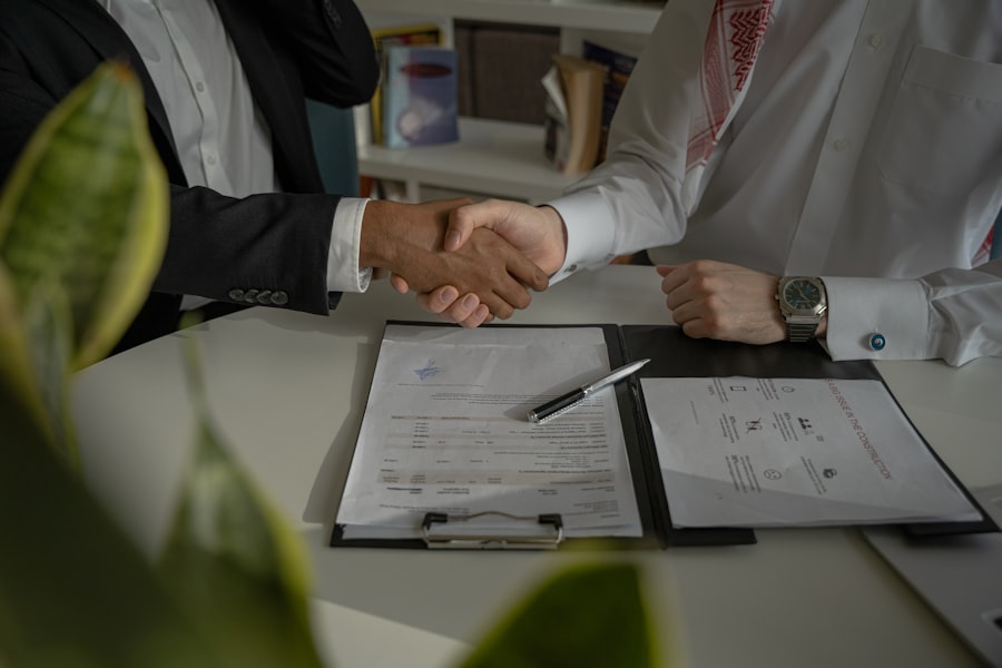 Two business partners shaking hands over a signed agreement
